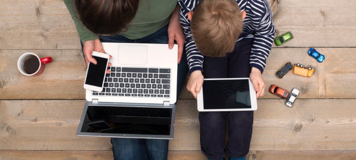 スマートフォン、パソコン、タブレットPCを持つ親子